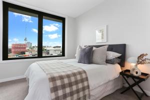 een slaapkamer met een bed en een groot raam bij Enfield Sky - Brand New Luxury Penthouse in Auckland
