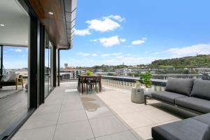 an apartment balcony with a view of the city at Enfield Sky - Brand New Luxury Penthouse in Auckland