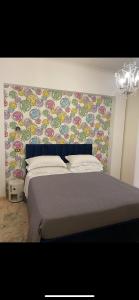 1 dormitorio con 1 cama con pared de flores en VHOMETREVI, en Roma