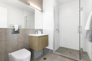 een badkamer met een toilet, een wastafel en een douche bij Enfield Sky - Brand New Luxury Penthouse in Auckland