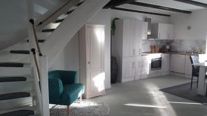 a kitchen with white cabinets and a staircase in a room at Gästehaus Storchenhof in Niepars