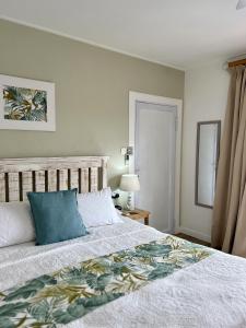 ein Schlafzimmer mit einem Bett mit einem blauen Kissen darauf in der Unterkunft The Runway Lodge in Pointe Larue