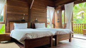 a bedroom with a large bed in a room with a window at Big Tree Cottages in Beadonābād