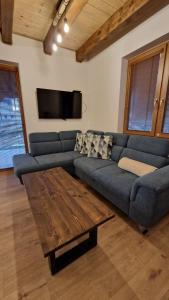 a living room with a blue couch and a wooden table at Mytho 1 in Mýto pod Ďumbierom