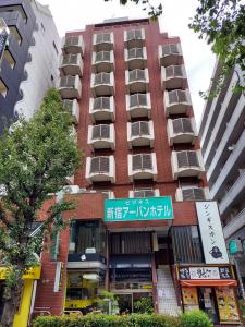 a tall red brick building with a sign on it at Shinjuku Urban Hotel in Tokyo