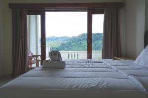 GREEN RINJANI في بايان: غرفة نوم بسرير كبير مع نافذة كبيرة