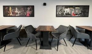 a room with tables and chairs and a wall with pictures at Vila Vyšehrad in Český Krumlov