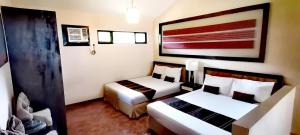 pokój hotelowy z 2 łóżkami i obrazem na ścianie w obiekcie Unit 306 Alta Vista de Boracay by David w mieście Boracay