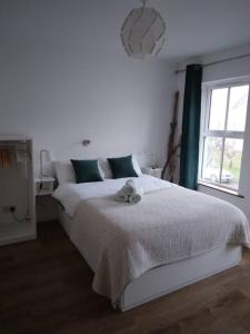 a bedroom with a white bed with a teddy bear on it at Big Blue in Clonakilty