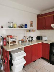 uma cozinha com armários vermelhos e uma bancada em Big Blue em Clonakilty