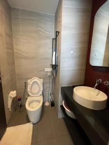 a bathroom with a toilet and a sink at EDGE Central Pattaya in Pattaya Central