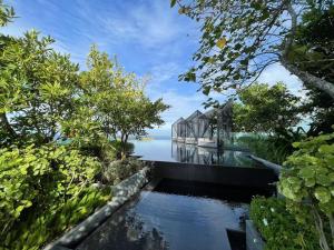 a glass house on the water with trees at EDGE Central Pattaya in Pattaya Central