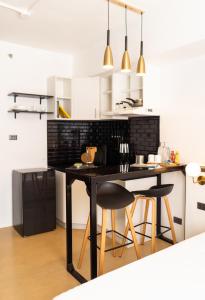 a kitchen with a black table and two chairs at Stylish Studio @AvidaTowersAtria in Iloilo City
