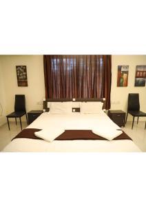um quarto com uma cama grande e 2 cadeiras em Blue Corner 4BHK em Lonavala