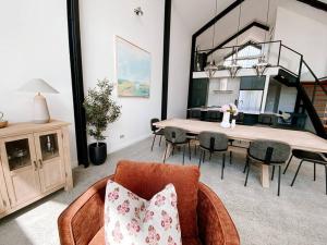 ein Wohnzimmer mit einem Tisch und Stühlen sowie ein Esszimmer in der Unterkunft Le Soleil new villa, golf & heated pool in Dunsborough