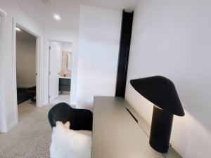 Le Soleil new villa, golf & heated pool في دانسبورو: غرفة معيشة بها كرسي أسود وبيضاء ومصباح