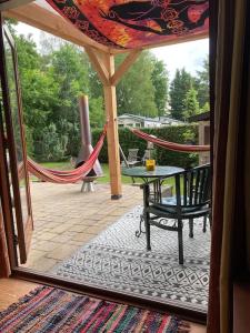 a patio with a hammock and a table and a hammock at Welcome, relax and enjoy your stay in Putten