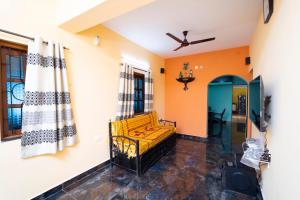 a living room with a yellow couch and orange walls at Stefleena's Nest in Loutolim