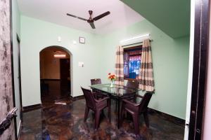 a dining room with a glass table and chairs at Stefleena's Nest in Loutolim