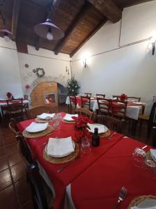 une salle à manger avec une table et des nappes rouges dans l'établissement Masseria Tarantini, à Castel del Monte
