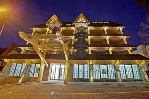 ein großes Gebäude mit beleuchteter Fassade in der Nacht in der Unterkunft Rysy Boutique Hotel in Zakopane
