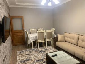 sala de estar con sofá, mesa y sillas en Dream Home, en Baku