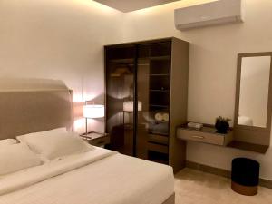 a bedroom with a white bed and a mirror at Inbar Residence إنبار ريزدينس شقة عائلية متكاملة in Riyadh