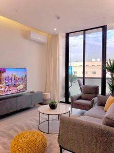 ein Wohnzimmer mit einem Sofa und einem TV in der Unterkunft Inbar Residence إنبار ريزدينس شقة عائلية متكاملة in Riad