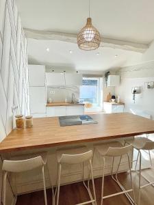 a kitchen with a large wooden table and stools at Appartement 2 chambres en plein centre ville in Chalon-sur-Saône