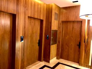 einen Flur mit Holzwänden und zwei Türen in der Unterkunft Inbar Residence إنبار ريزدينس شقة عائلية متكاملة in Riad