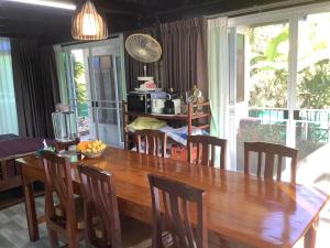 comedor con mesa de madera y sillas en BanLomLak en Sukhothai