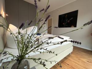 una stanza con un vaso con fiori viola di NEU! Feriendomizil TraumZeit 1 mit Sauna & Garten a Göhren-Lebbin