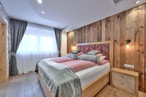 a bedroom with a bed with a wooden wall at Villa Ambach in Oetz