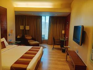 Habitación de hotel con cama y TV en Mirage Hotel en Bombay