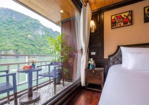 a bedroom with a bed and a balcony with a view at Arcady Boutique Cruise in Ha Long