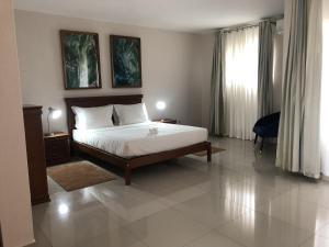 a bedroom with a bed and a large window at Inhambane Hotel Escola in Inhambane