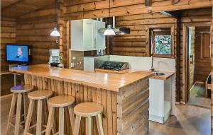 una cocina con barra con taburetes en una cabaña en Pet Friendly Home In Meppen With House A Panoramic View, en Meppen