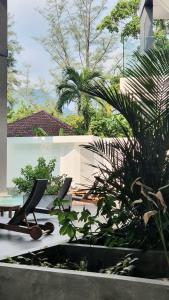 un patio con 2 sillas y algunas plantas en CYAN Resort Kamala Beach Apartments Condominiums en Kamala Beach