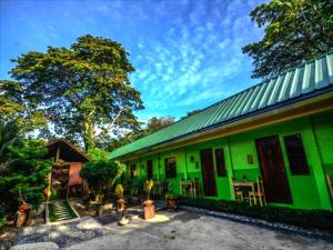 um edifício verde com um telhado verde em OYO 622 Butterfly Totem Guesthouse em Puerto Princesa