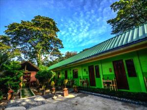 un bâtiment vert avec un toit vert dans l'établissement OYO 622 Butterfly Totem Guesthouse, à Puerto Princesa