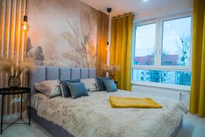 Un dormitorio con una cama con una manta amarilla. en Nowoczesny apartament Ludova, en Biskupiec