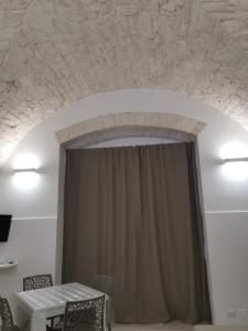 een kamer met een tafel en een plafond met een gordijn bij LA CASETTA DU MESTE in Noci