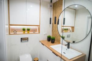 łazienka z umywalką i lustrem w obiekcie Nowoczesny apartament Ludova w mieście Biskupiec +18 zdjęć