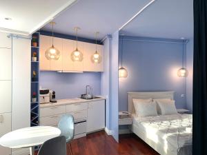 1 dormitorio con paredes azules, 1 cama y 1 mesa en Downtown Italian Studio en Bucarest