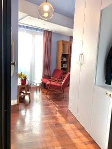 a hallway with a living room with a red chair at Downtown Italian Studio in Bucharest
