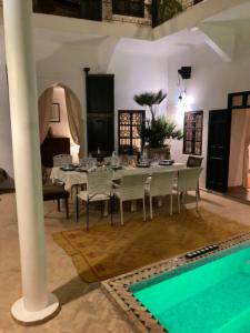 a dining room with a table and a swimming pool at Riad SASHA in Marrakesh