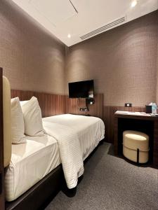 a bedroom with a bed and a desk with a television at Aerotel Cebu in Mactan