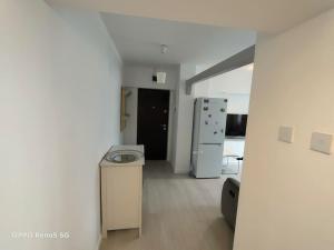 a white kitchen with a refrigerator and a counter at Ultracentral Ploiesti Apartment-Free Private Parking in Ploieşti