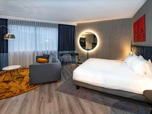 a hotel room with a bed and a living room at Mercure Antwerp City South in Antwerp