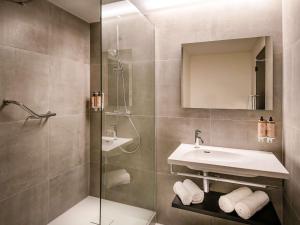 a bathroom with a sink and a shower at Mercure Antwerp City South in Antwerp